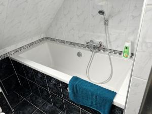 a bath tub in a bathroom with a blue towel at B&B Tina in Sneek