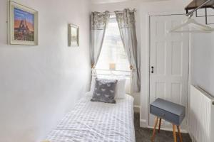 - une petite chambre avec un lit et une fenêtre dans l'établissement Mad Alice's Cottage, à Loftus