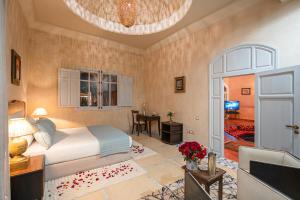 ein Schlafzimmer mit einem Bett und ein Wohnzimmer mit einem Tisch in der Unterkunft Palais Alcazar in Marrakesch