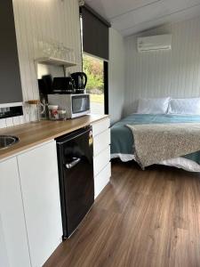 a small kitchen with a bed and a microwave at Mona Vale Country Estate in Hawarden