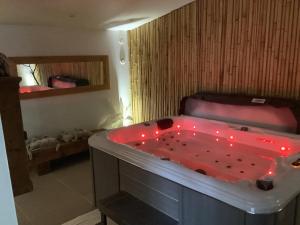 bañera con luces rojas en una habitación en Le carpe noctem, en Sérignan-du-Comtat