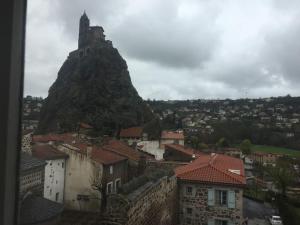a view of a mountain and a city with buildings at Très jolie appartement in Aiguilhe +4 photos