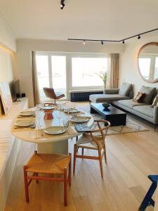 ein Wohnzimmer mit einem Tisch und einem Sofa in der Unterkunft Manon Knokke - appartement met zeezicht aan het Rubensplein in Knokke-Heist