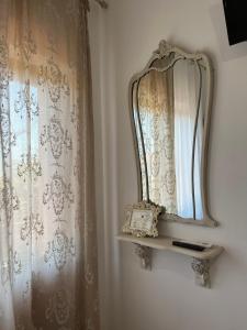 un espejo en una pared junto a una cortina en SALGE b&b RESIDENZA DI CHARME, en Colonnella