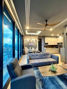 a living room with blue couches and a kitchen at Crystal Suite at Opus Kuala Lumpur in Kuala Lumpur