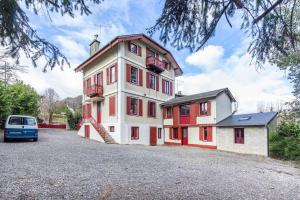 a large building with red windows and a van parked in front at Repaire du Bagnérais in Bagnères-de-Bigorre