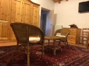 een kamer met 2 stoelen en een tafel op een tapijt bij Antica Osteria Pace in Moerna
