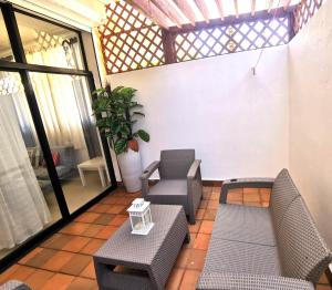een patio met stoelen en tafels en een raam bij Apartmán Mariscos in Los Corrales