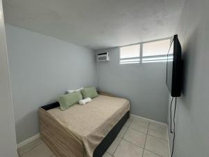 Dormitorio pequeño con cama y TV en 13th Floor Apartment with Nice View in Bahía A, en San Juan