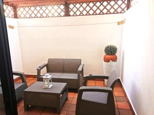 een veranda met stoelen, een tafel en een cactus bij Apartmán Mariscos in Los Corrales