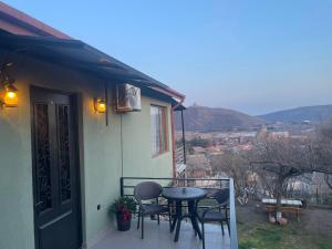 a patio with a table and chairs on a balcony at panorama in Mtskheta
