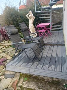 a deck with chairs and a statue of a woman at le calme atlantique in Pornic