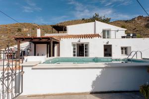 une maison blanche avec une piscine en face de celle-ci dans l'établissement Finca La Herradura, à La Herradura