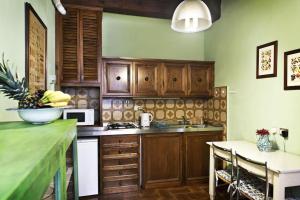 eine Küche mit Holzschränken und einem Tisch mit einer Schale Bananen in der Unterkunft Vigna1- Big 1 bedroom apartment in Florence center in Florenz