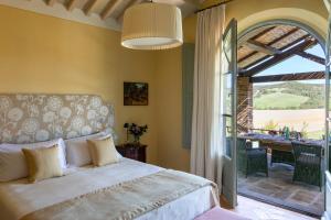 a bedroom with a bed and a patio with a table at Borgo Pignano in Pignano