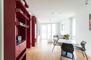 a living room with red cabinets and a table and chairs at HM • Smart Studio with Terrace in Vienna