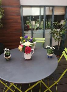 a table with three vases of flowers on it at Chambre et salle d'eau privées dans maison de ville in La Roche-sur-Yon