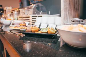a buffet line with pastries and a plate of food at Hotel Upstalsboom Langeoog in Langeoog