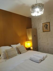 a bedroom with a large white bed with a lamp at La Maison Olivia in La Rivière-Saint-Sauveur
