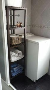 baño con estante con toallas y aseo en One bedroom house with wifi at Bermiego, en Bermiego
