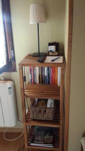 un estante de libros con libros y una lámpara. en One bedroom house with wifi at Bermiego, en Bermiego