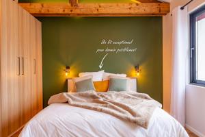 ein Schlafzimmer mit einem Bett mit einer grünen Wand in der Unterkunft Studio Le Vau in Bagneux