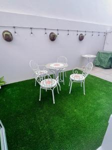 a patio with four chairs and a table with green grass at Relaxing Seaside Apartment in scenic Houtbay in Cape Town