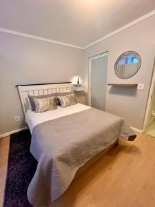 a bedroom with a large bed and a round mirror at Relaxing Seaside Apartment in scenic Houtbay in Cape Town