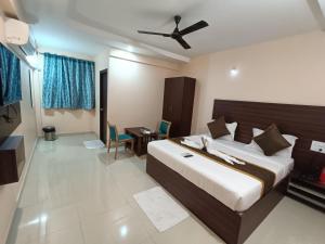Schlafzimmer mit einem großen Bett und einem Deckenventilator in der Unterkunft Hotel Classic Comfort in Bangalore