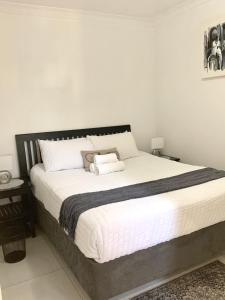 a bedroom with a large bed with white sheets at Modern apartment, a home away from home right next to the beachfront in Summerstrand +13 photos