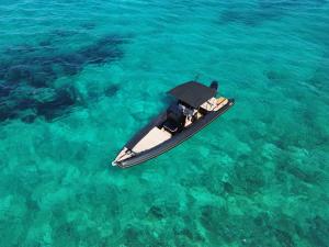 un pequeño barco flotando en el agua azul en CycladesCharters: Discover Hidden Gems in Paros!, en Kampos