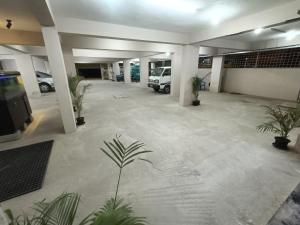 Hotel Classic Comfort في بانغالور: موقف سيارات فارغ مع نباتات الفخار في مبنى