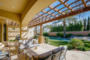 a patio with a table and chairs under a glass roof at Luxe Poolside Paradise - Resort Style Yard in Scottsdale