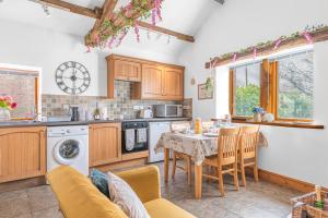 a kitchen with a table and chairs in a kitchen at The Byre, Melmerby in Gamblesby +10 photos