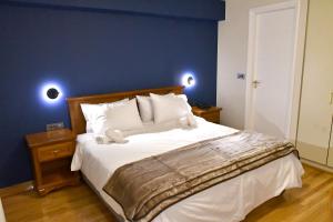 een slaapkamer met een groot bed met een blauwe muur bij Porto Nafplio in Nafplio