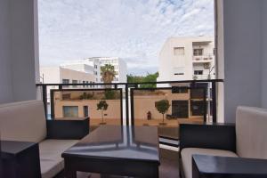 a balcony with a table and a view of a city at The Place To Be - Agadir Centre in Agadir