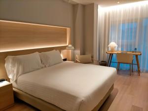 1 dormitorio con 1 cama blanca grande y escritorio en Zenit Coruña en A Coruña
