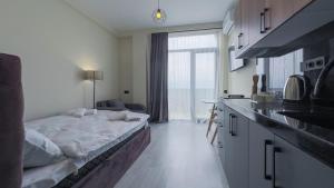 Zimmer mit einem Bett und einer Küche mit einem Fenster in der Unterkunft Lux Apartments G62 in Tbilisi City