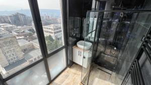 ein Bad mit einer Dusche und Stadtblick in der Unterkunft Lux Apartments G62 in Tbilisi City