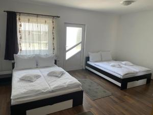 two twin beds in a room with a window at Casa Flamingo in Sovata