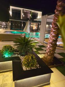 a resort with a swimming pool at night at Elysee Villa in Al Rama