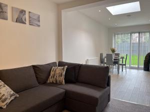 a living room with a couch and a dining room at Wembley Stadium, Modern&Cozy Apartment with Garden in London