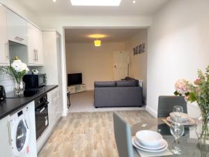 a kitchen and a living room with a couch at Wembley Stadium, Modern&Cozy Apartment with Garden in London