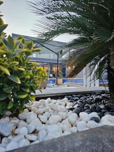 a rock garden in front of a house with a palm tree at Elysee Villa in Al Rama +12 photos