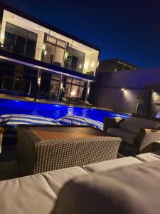 a house with a swimming pool at night at Elysee Villa in Al Rama
