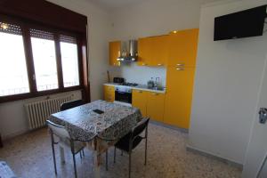 サルヴェにあるCasa Elena Giallaのキッチン(テーブル、椅子、黄色のキャビネット付)