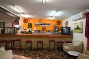 bar z czerwonymi stołkami w restauracji w obiekcie Artesian Motor Inn w mieście Coonamble