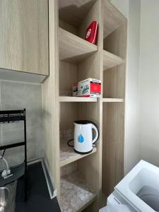 a cupboard with a mug and a box in it at Cozy Homely Studio @ Youth City Residence Nilai in Nilai