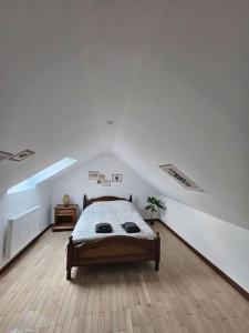 a white room with a bed in a attic at La petite bulle in Villeneuve-sur-Yonne
