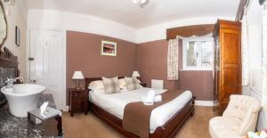 a bedroom with a bed and a tub and a sink at Stockghyll Cottage in Bowness-on-Windermere